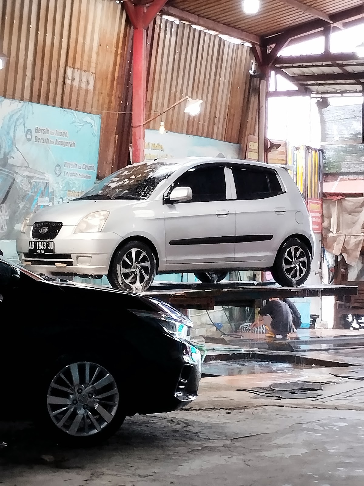 Mobil diangkat dengan lift hidrolik untuk dicuci di COLOMONDRO