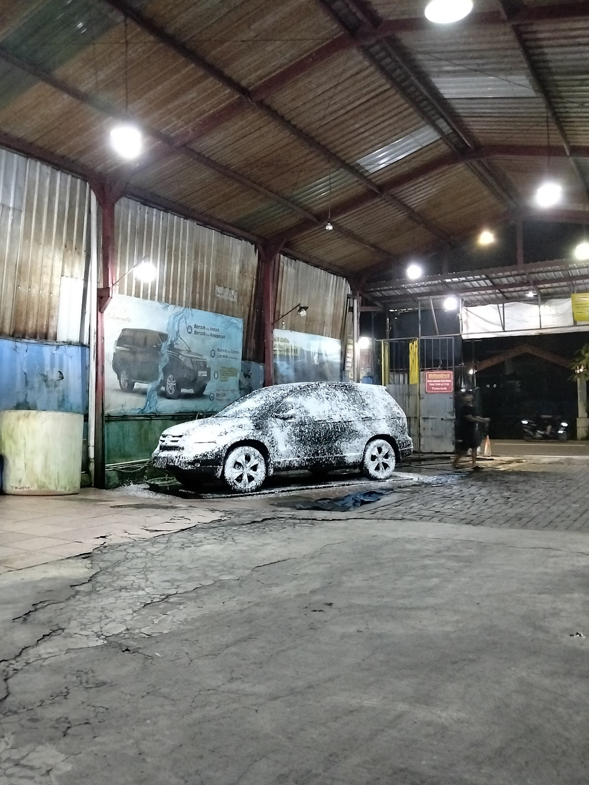 Mobil tertutup busa salju di area cuci beratap COLOMONDRO
